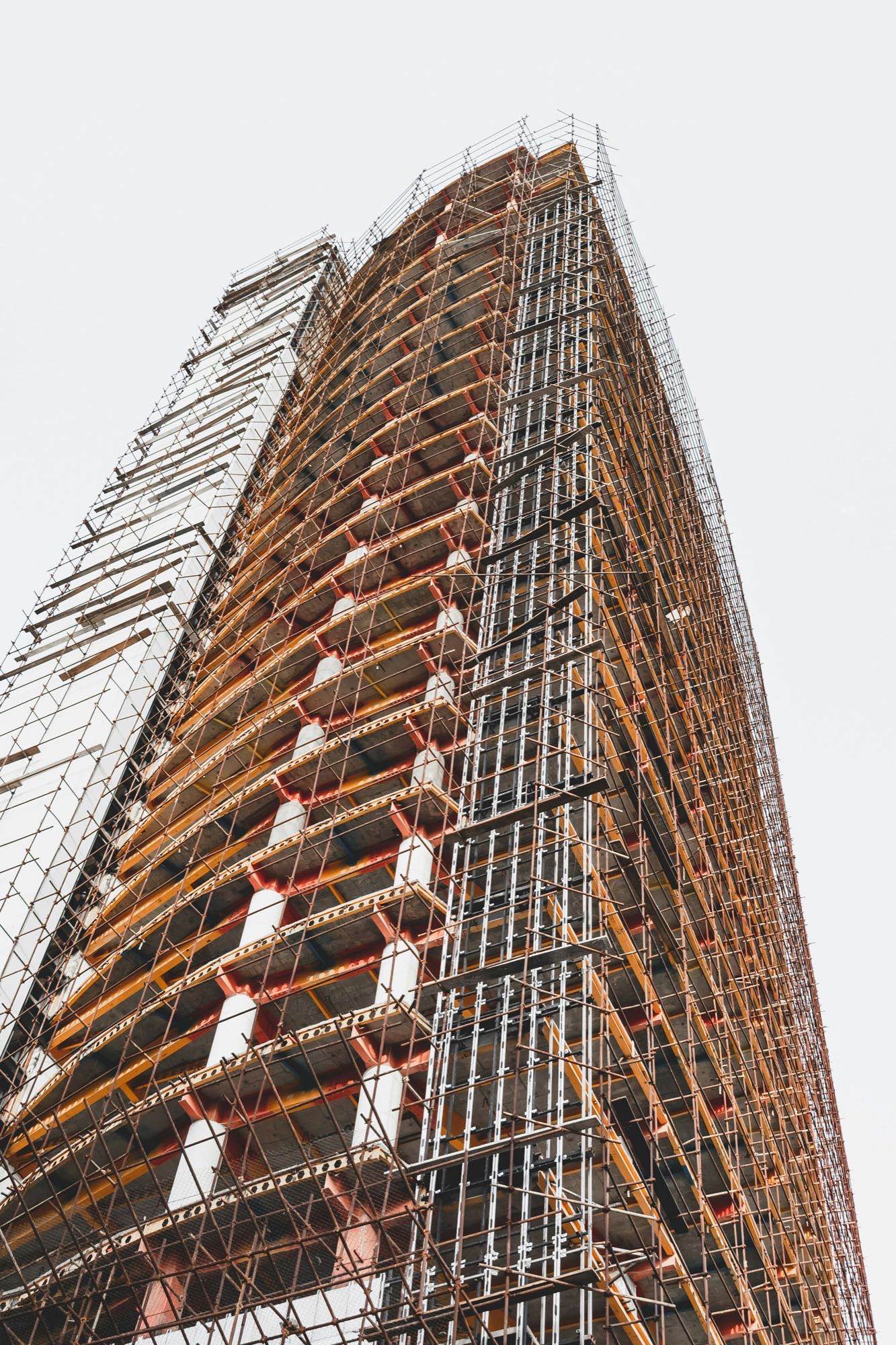 Ponteggio che avvolge la facciata di un edificio in costruzione, vista dal basso